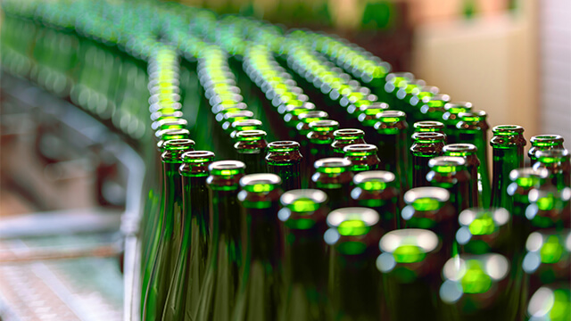 Green bottles on conveyor belt in factory